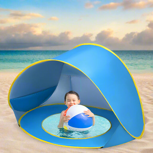 Child playing with a ball inside a blue beach tent on a sandy beach.