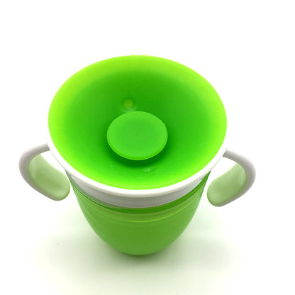 Green sippy cup with a white rim on a white background
