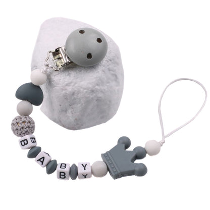 Baby pacifier chain with gray and white beads on a white background
